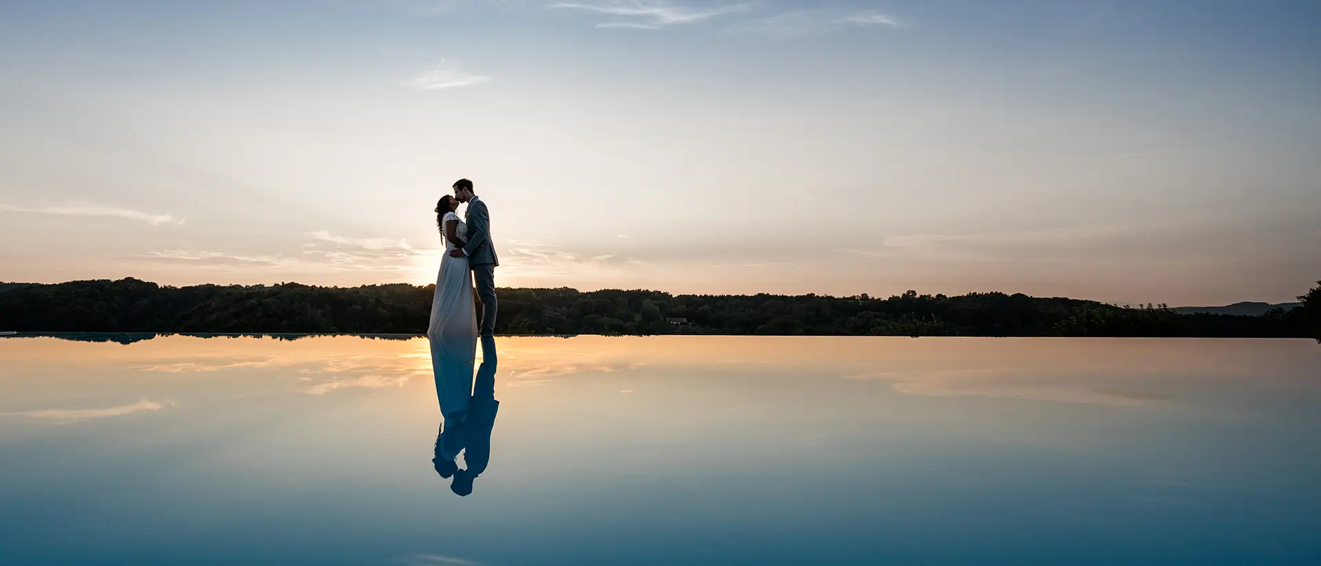Hochzeitsfotograf Burgenland — Brautpaar Kuss bei Goldener Stunde in der Wiese mit langer Schleppe